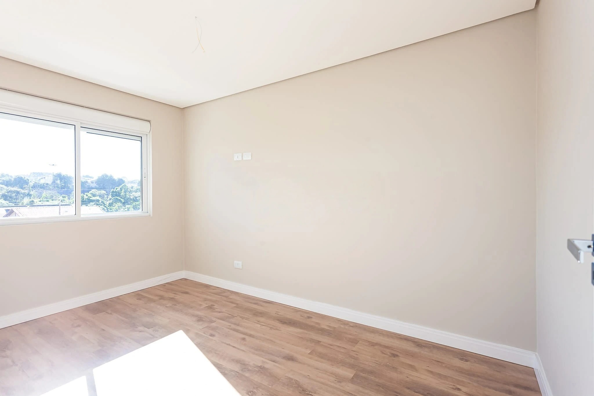 Quarto com janela ampla e piso laminado